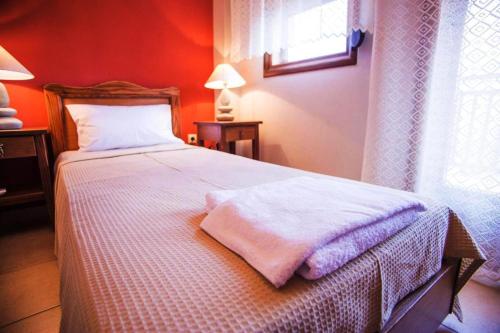 a bedroom with a bed with a white blanket at Nea Roda Apartments in Nea Roda