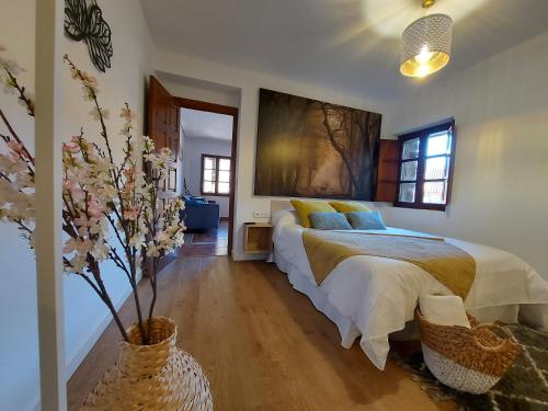 Apartamentos Nevandi في Pido: غرفة نوم مع سرير و مزهرية مع الزهور