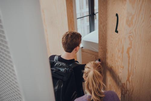 a young man and a woman standing in a room at Cabane Urbaine 3 - centre in Namur