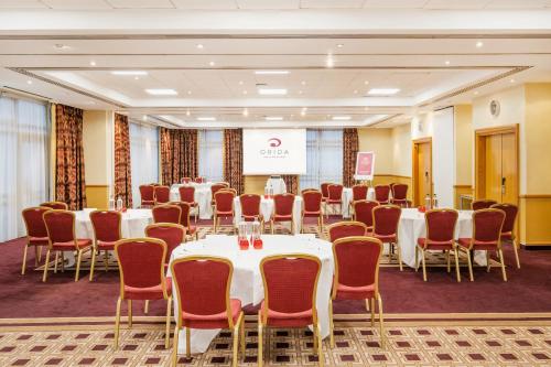 a conference room with tables and chairs and a podium at Orida Maidstone in Maidstone