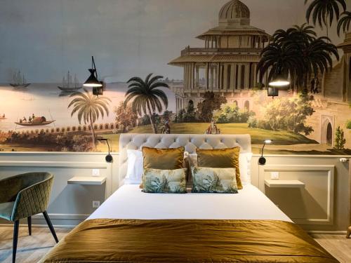 a bedroom with a large white bed with a mural at Villa Pruly Hotel Cannes Centre in Cannes