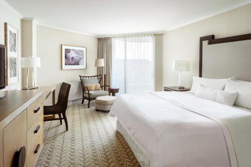 a hotel room with a large white bed and chairs at Moana Surfrider, A Westin Resort & Spa, Waikiki Beach in Honolulu