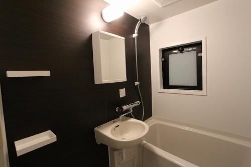 a bathroom with a sink and a toilet and a mirror at HOTEL LiVEMAX Nihonbashi Hakozaki in Tokyo