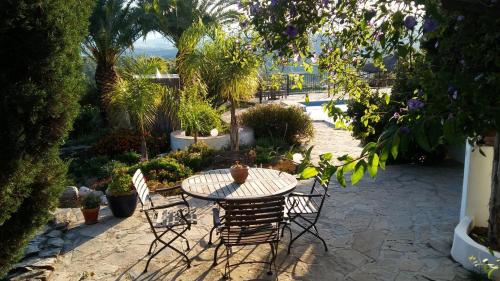 un patio con mesa y sillas en un jardín en B&B Casa Domingo en Alora