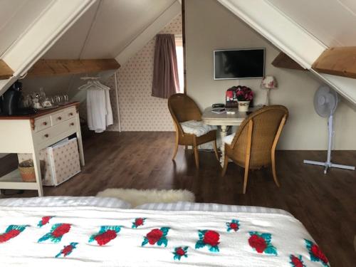 a bedroom with a bed and a desk and a table at La Vie en Rose Zierikzee in Zierikzee