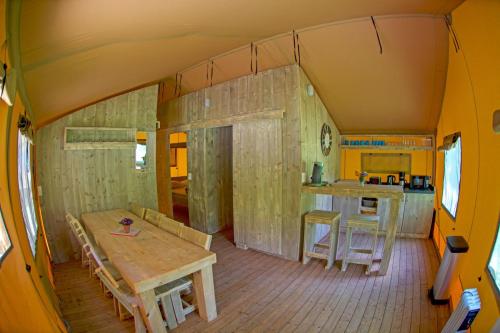 una habitación con una mesa y una cocina en una casa en Parc de vacances La Draille en Souillac