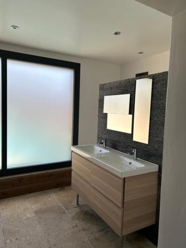 baño con lavabo y ventana grande en La chambre de Léopoldine, en Vérargues