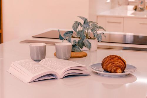 un livre ouvert sur une table avec une assiette de pain dans l'établissement Lovely Apartment, heart of Paris center, à Paris