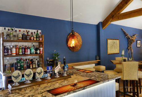 un bar en un restaurante con una pared azul en The Pickled Pheasant en Holmfirth