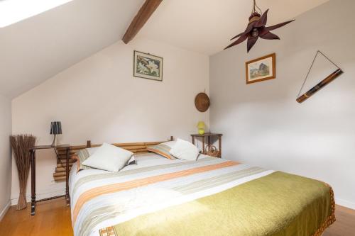 Schlafzimmer mit einem Bett und einem Deckenventilator in der Unterkunft Maison Meslaie - Maison pour 8 avec piscine in Beaumont-en-Véron