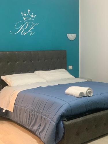 a bed in a room with a blue wall at New zarà in Villa San Giovanni