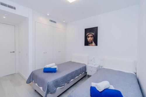a bedroom with two beds and a picture on the wall at Al-1103 Estepona - Apartment - Alcazaba Lagoon in Estepona