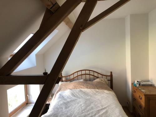 a bedroom with a wooden bed in a attic at La Masure in Les Rameaux