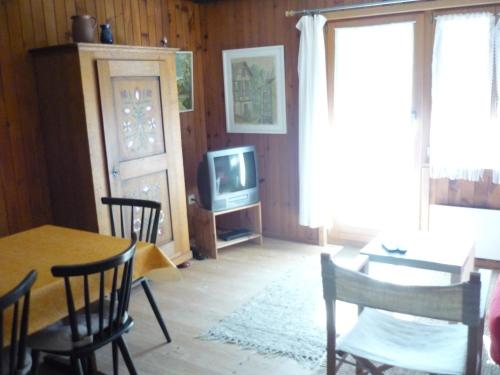 a living room with a table and a tv at Ferienwohnung Bischoff in Schwarzsee