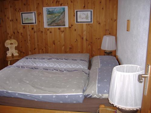 a small bedroom with a bed and a lamp at Ferienwohnung Bischoff in Schwarzsee