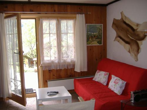 a living room with a red couch and a table at Ferienwohnung Bischoff in Schwarzsee