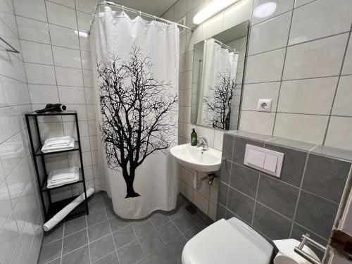 a bathroom with a shower curtain with a tree on it at Panoramic Studio Apartment with stunning view - Free Parking in Reykjavík