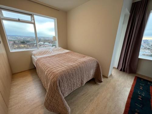 1 dormitorio con cama y ventana grande en Panoramic Studio Apartment with stunning view - Free Parking, en Reikiavik