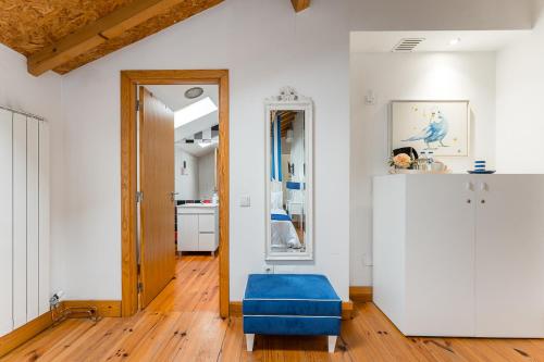 a living room with a blue ottoman and a mirror at R3 Service - Five Senses in Coimbra in Coimbra