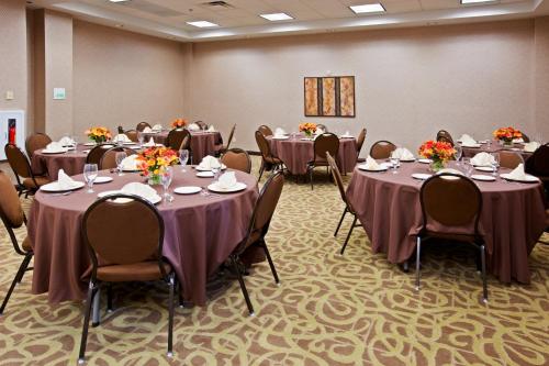 a conference room with tables and chairs with flowers on them at Holiday Inn Florence by IHG in Florence