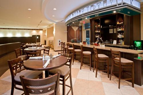a restaurant with tables and chairs and a bar at Holiday Inn Florence by IHG in Florence