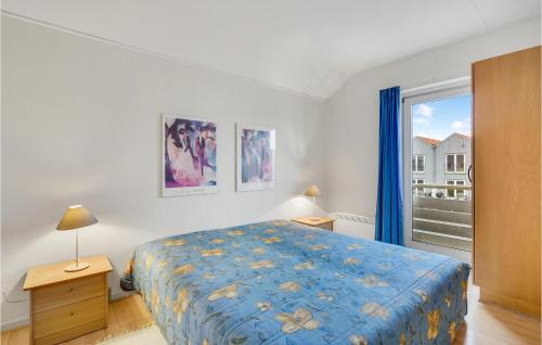 a bedroom with a blue bed and a window at Nice Apartment In Rudkbing With Wifi And 2 Bedrooms in Rudkøbing