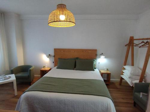 a bedroom with a large bed and a pendant light at Silver Home in Nazaré