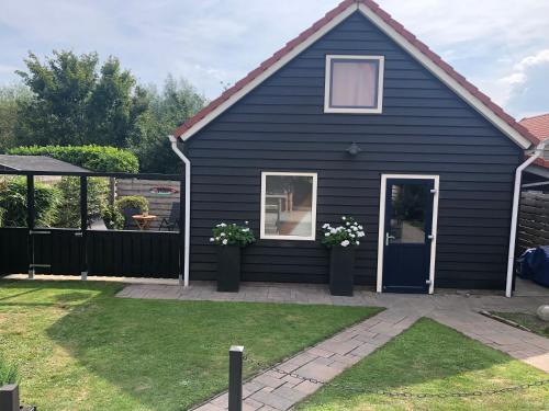 a black house with flowers in a yard at La Vie en Rose Zierikzee in Zierikzee