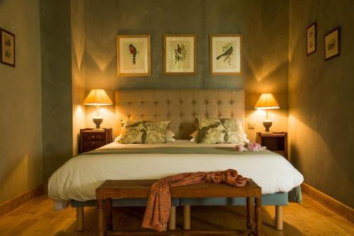 une chambre avec un grand lit et deux lampes dans l'établissement Bastide des Tourelles pour 20 pers. Piscine & Spa, à Marzens