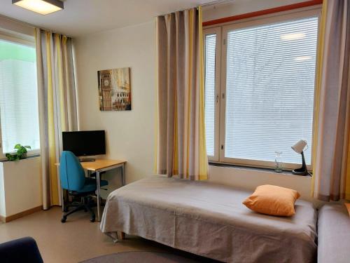 Schlafzimmer mit einem Bett und einem Schreibtisch mit einem Computer in der Unterkunft Hostel Teopolis in Tampere
