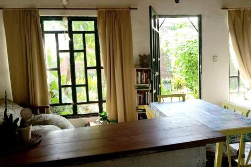 een woonkamer met een houten tafel en 2 ramen bij Relajante y amplio con jardín in Presidencia Roque Sáenz Peña