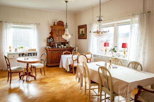 a dining room with tables and chairs and windows at Sweet Dreams B&B Ullared in Ullared