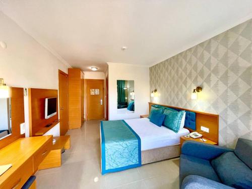 une chambre d'hôtel avec un lit et un canapé dans l'établissement Green Forest Holiday Village, à Ölüdeniz