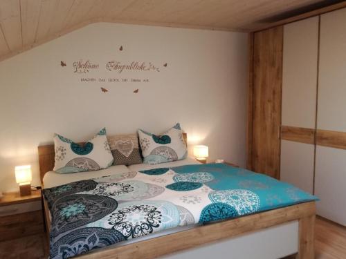 a bedroom with a bed with blue and white pillows at Ferienhof Fernblick in Lalling