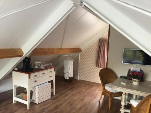 a room with a desk and a table in a attic at La Vie en Rose Zierikzee in Zierikzee
