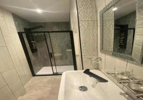 a white bathroom with a sink and a mirror at Alexander Hotel in Blackpool