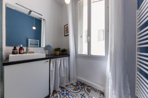 une salle de bain avec un lavabo et une fenêtre dans l'établissement La Bonne Mère - Superbe appartement vue Notre Dame, à Marseille