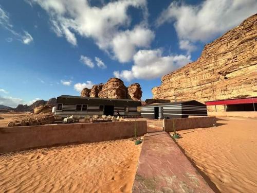 a building in the middle of a desert with mountains at Wadi Rum Star Camp in Wadi Rum