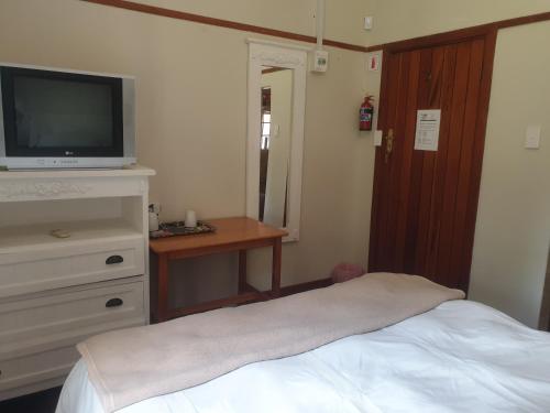 a bedroom with a bed and a tv on a dresser at The Sleeping Bao B&B in Pietermaritzburg