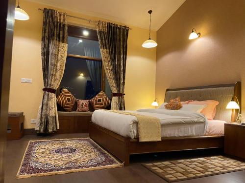 a bedroom with a large bed and a window at Sangita Resorts in Nainital
