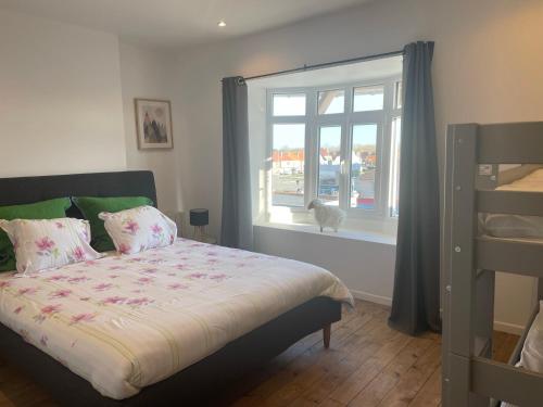 - une chambre avec un lit et un chat donnant sur la fenêtre dans l'établissement Musica Bray-Dunes, à Bray-Dunes