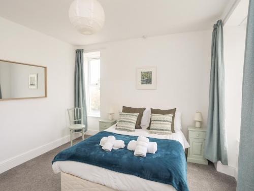 a bedroom with a bed with two stuffed animals on it at Gwynant - Morfa Nefyn in Pwllheli