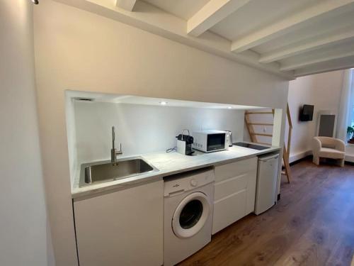 uma cozinha com um lavatório e uma máquina de lavar roupa em REIMS CATHEDRALE - Mairie / Boulingrin em Reims