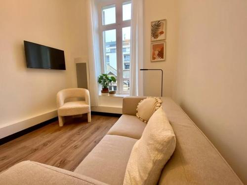 uma sala de estar com um sofá e uma televisão em REIMS CATHEDRALE - Mairie / Boulingrin em Reims
