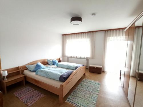 um quarto com uma cama com almofadas azuis em Haus Schmid em Falkenfels