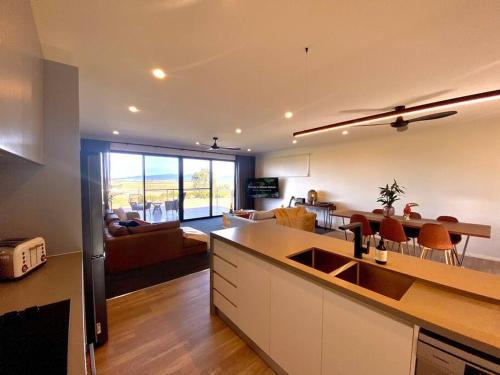 a kitchen and living room with a couch and a table at Wamoon Retreat - Luxe House in Yanakie