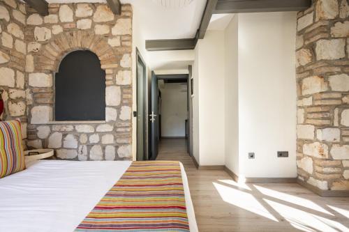 a bedroom with a stone wall and a bed with a rug at Pleasant Flat near Hadrians Gate in Antalya