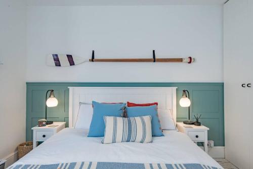 sypialnia z białym łóżkiem z niebieskimi i czerwonymi poduszkami w obiekcie Seabreeze Cottage w mieście Walmer