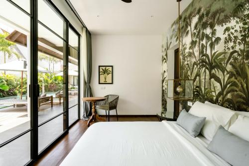 - une chambre avec un grand lit et une table dans l'établissement Anam Villas Complex Canggu, à Canggu