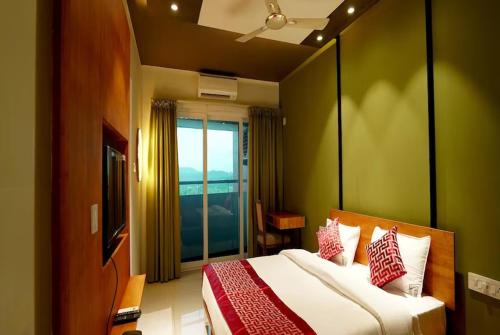 a bedroom with a large bed with a large window at THE TERRACE MANJERI in Manjeri